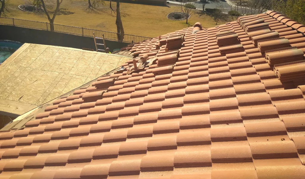 Newly installed terracotta roof tiles with a partially constructed wooden roof extension, enhancing the home's curb appeal and structural integrity.