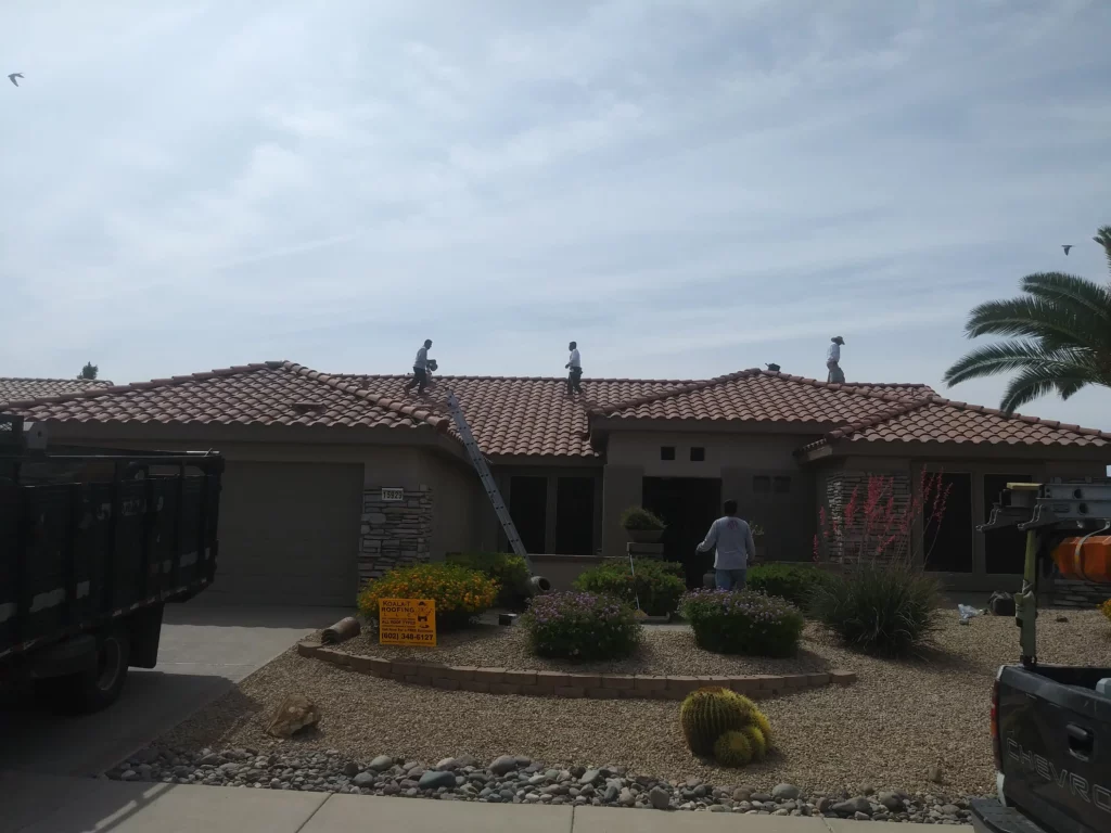 Roofers working on a residential tile roof, performing maintenance and repairs to ensure optimal condition.