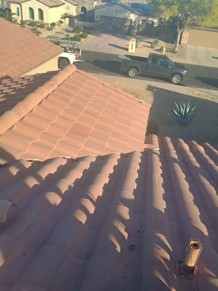 Close-up view of a Arizona residential tile roof with visible lifted and misaligned tiles, showing the need for repair or replacement.