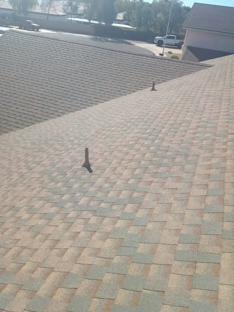 Newly installed asphalt shingle roof showing proper alignment and ventilation pipes